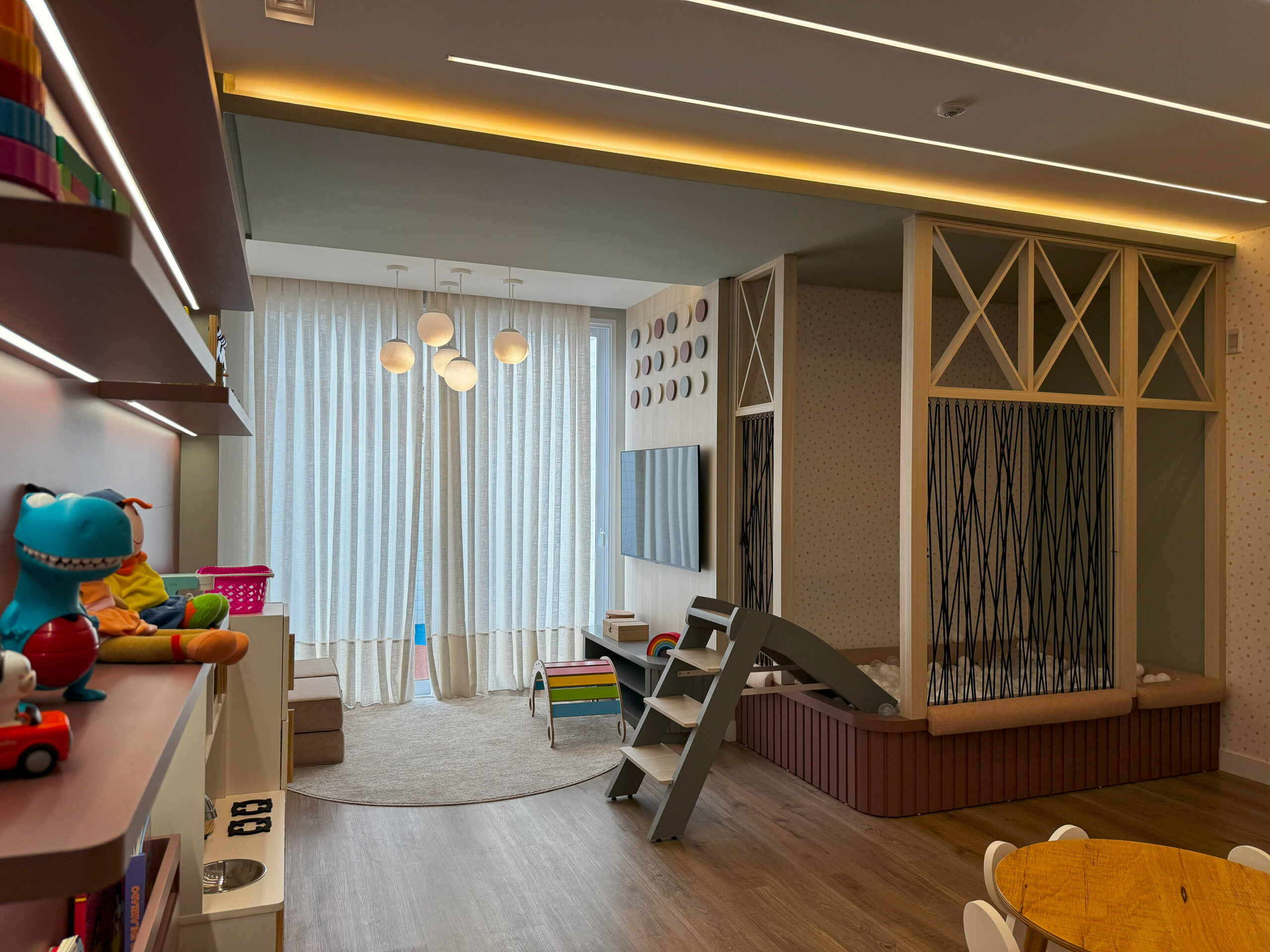 Sala com painel ripado de madeira e TV